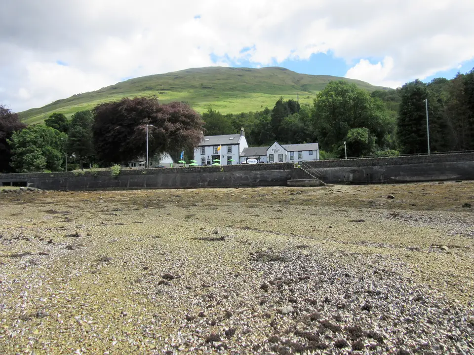 White buildings below a green hill beside the shore at Arrochar