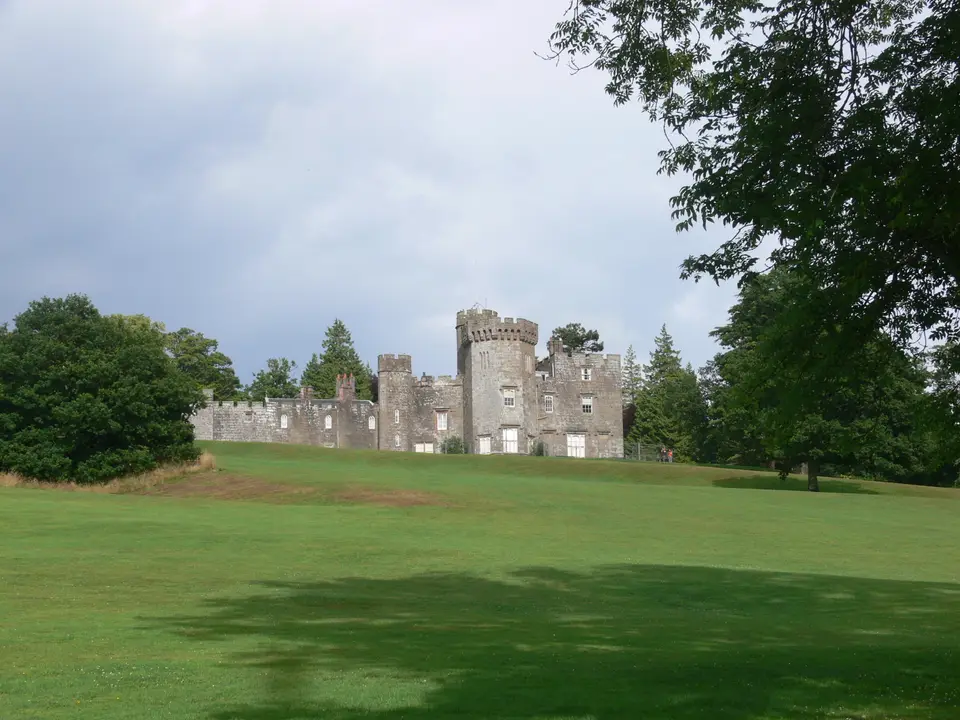 Balloch Castle seen across the open lawn of Balloch Castle Country Park on a grey day