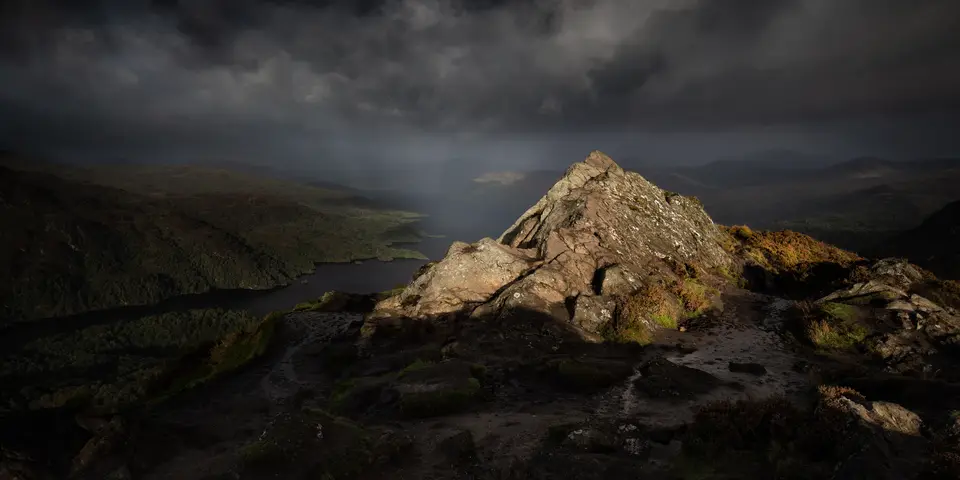 First light catching the rocky summit of Ben A'an under a dark sky