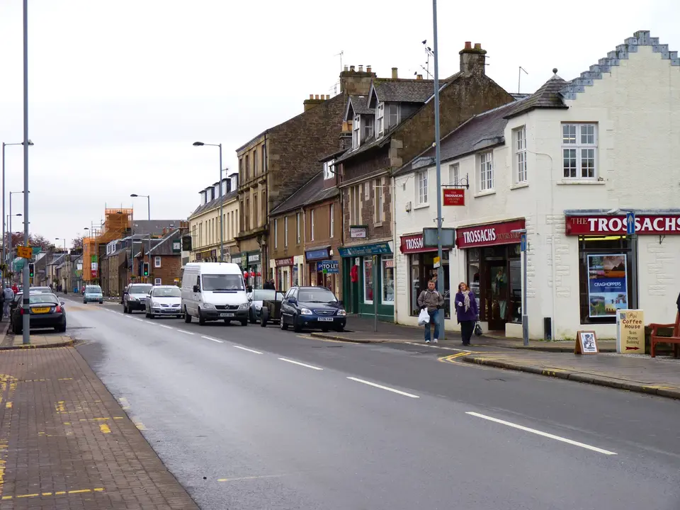 Main Street in Callander with shops on both sides and a white stepped gable on the right
