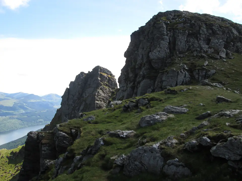 Rock towers on the Cobbler's ridge with a loch and hills far below
