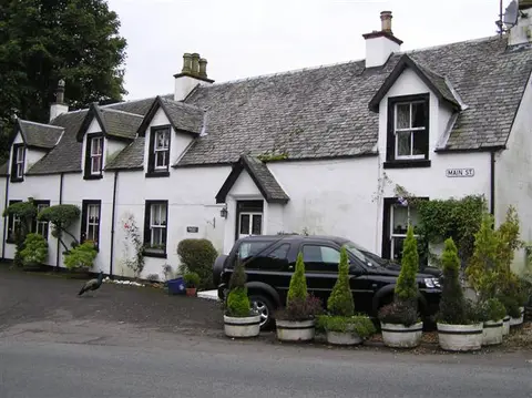 A whitewashed cottage on Main Street, Drymen, with a car parked outside