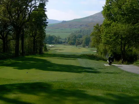 A fairway at Loch Lomond Golf Course with hills rising beyond the trees