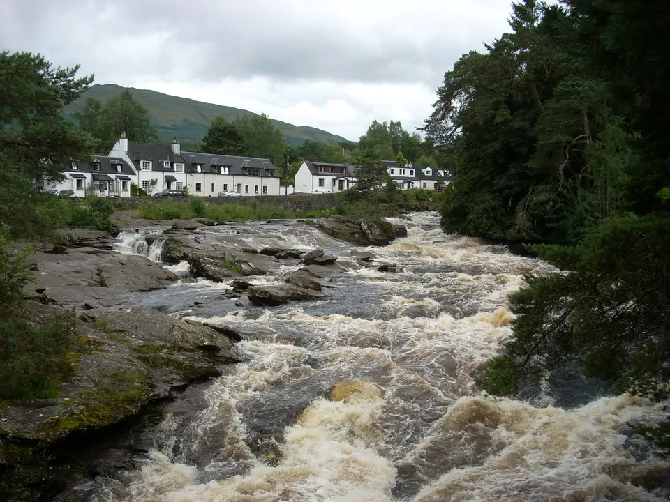The Falls of Dochart in spate, with the white houses of Killin on the bank behind