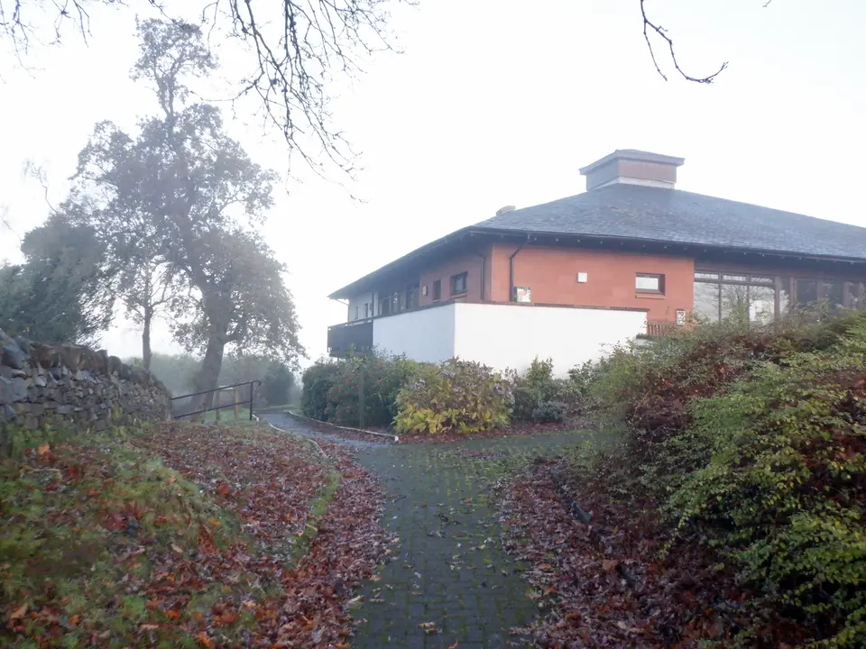 Kilmaronock Millennium Hall in Gartocharn, a brick hall with a pitched roof beside a leafy path