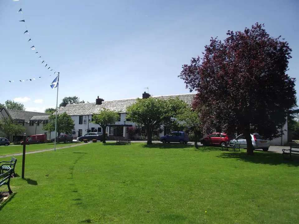 The green at Drymen’s village square, with a purple-leaved tree and white cottages behind
