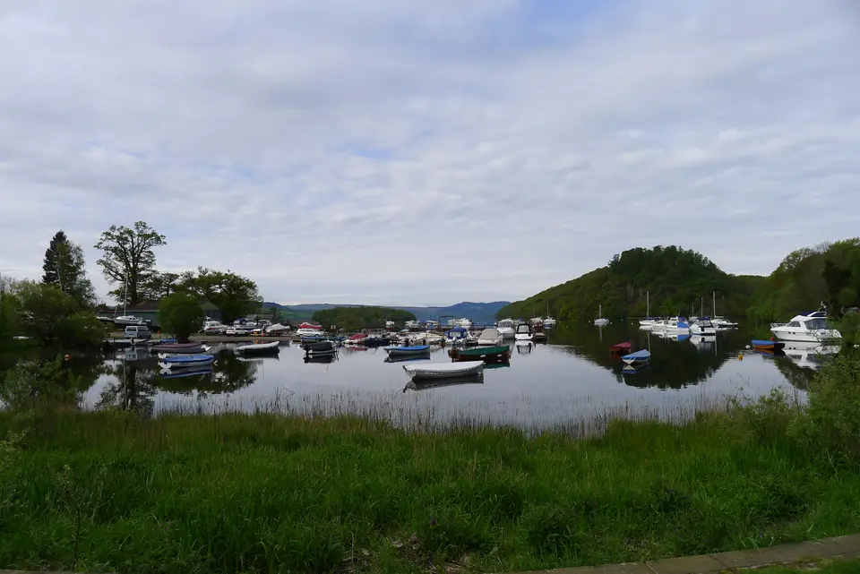Small boats moored in the sheltered harbour of Balmaha Bay