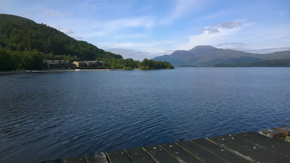 Loch Lomond from the pier at Luss, with a wooded shore and hills across the water