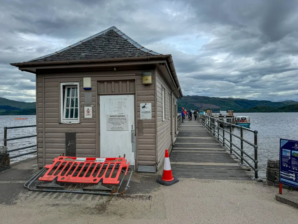 Luss Pier on Loch Lomond with the pier building and the jetty running out towards the water