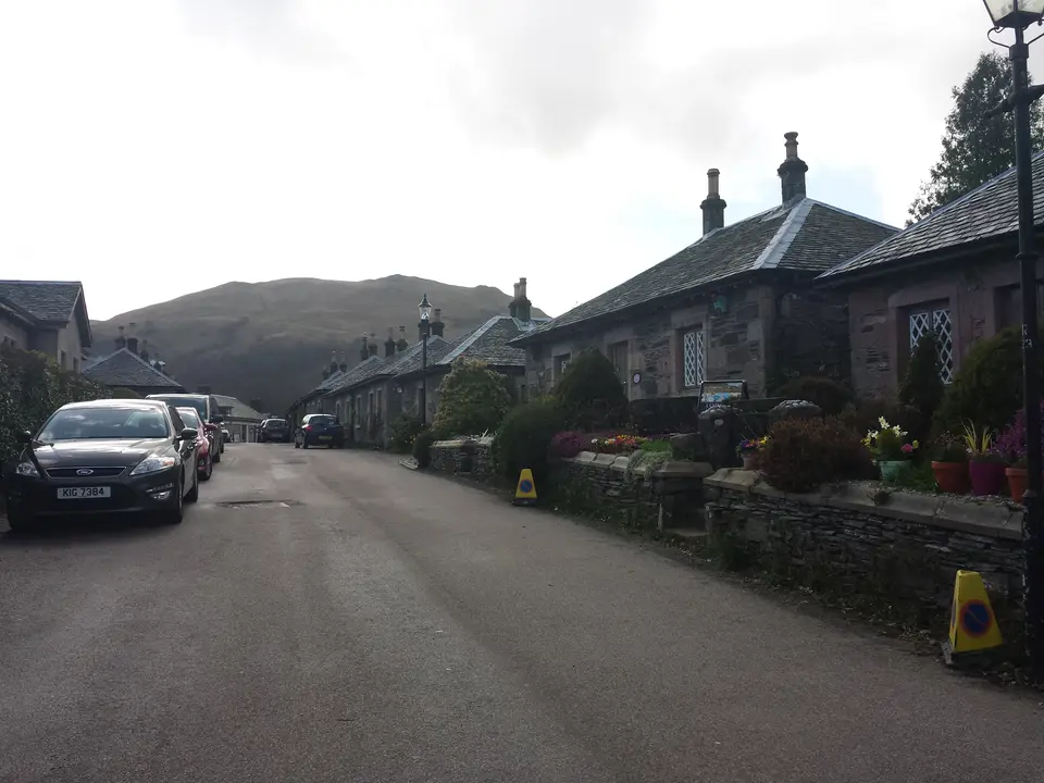 The village street with cars parked along the kerb