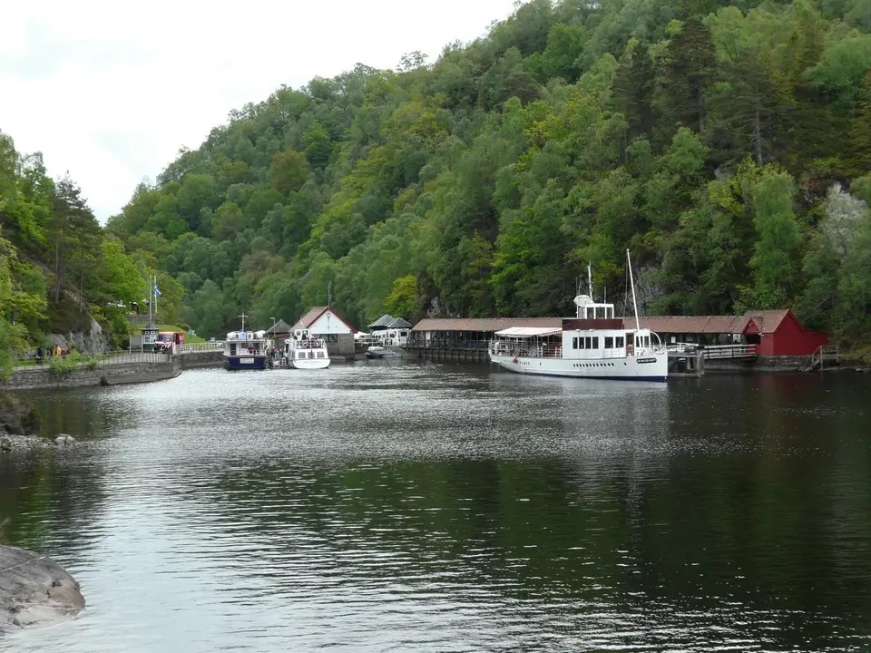 Trossachs Pier on Loch Katrine with a steamship moored beside the wooded shore