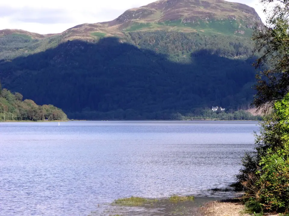 Still water of Loch Lubnaig with a large dark hill reflected along its far shore